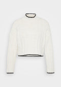 Gekürzter Pullover aus off-white Strickstoff mit gerippter Textur. Verfügt über einen hohen Kragen und einen schwarzen Rand entlang des Ausschnitts und Saums.