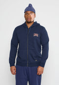 Marineblaue Zip-Hoodie mit vorderen Taschen, gerippten Bündchen und rotem O'Neill-Logo. Getragen mit blauen Sweatpants und einer blauen Strickmütze.