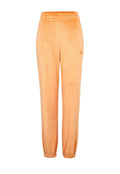 Orange Velours-Jogginghosen mit elastischem Bund und Bündchen am Saum. Ein kleines Logo ist auf der linken Seite nahe der Hüfte aufgedruckt.