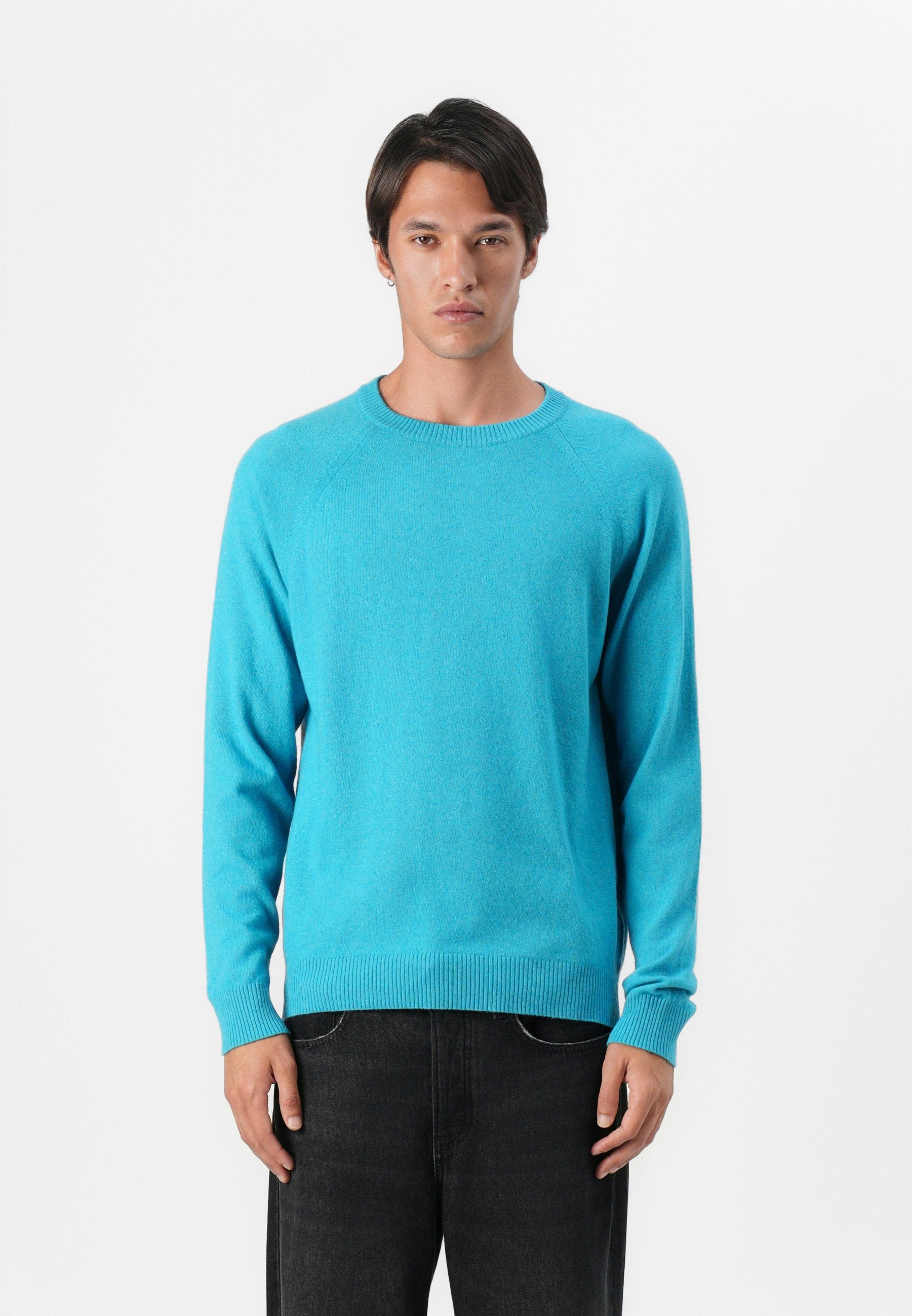 Blauer Strickpullover mit Rundhalsausschnitt und gerippten Bündchen, mit einer glatten Textur und langen Ärmeln, kombiniert mit schwarzen Jeans.