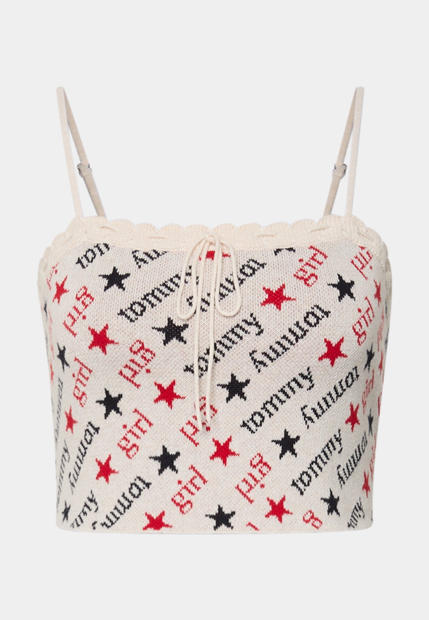 Gestricktes Crop-Top mit einem cremefarbenen Grundton sowie roten und schwarzen Sternen und Textmustern. Dünne verstellbare Träger und ein Schnürdetail vorne.