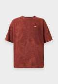 Rostfarbendes T-Shirt mit kurzen Ärmeln und kleinem roten "DIESEL"-Logo auf der linken Brust, auf einem schlichten weißen Hintergrund präsentiert.