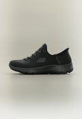 Schwarzer Skechers Slip-On Sneaker mit texturierter Oberseite, schnürähnlichem Elastikband und flexibler Sohle, auf neutralem Hintergrund gezeigt.