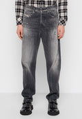 Ausgewaschene schwarze Jeans mit lockerem Schnitt, ausgestattet mit abgetragenen Details, fünf Taschen und einem Knopfverschluss. Tragen Sie dazu schwarze Schuhe.