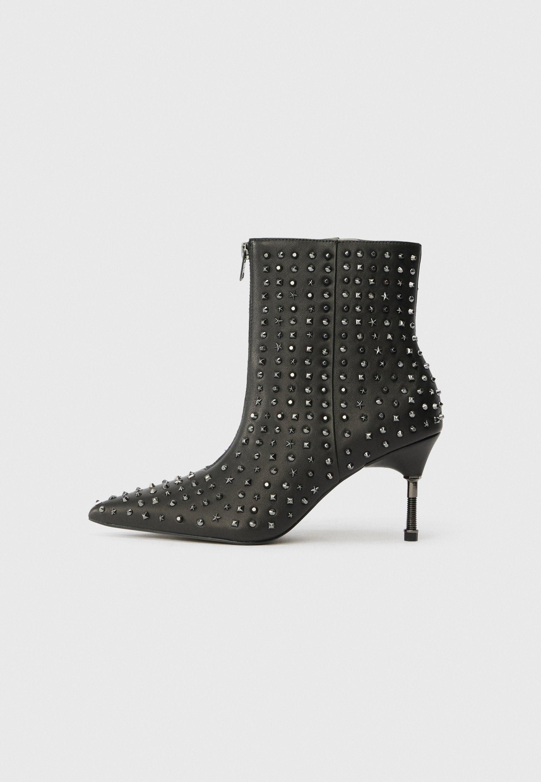 Schwarze Leder-Stiefeletten mit spitzen Zehen, verziert mit silbernen Nieten und sternförmigen Akzenten, ausgestattet mit einem mittelhohen Absatz und einem seitlichen Reißverschluss.