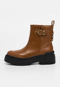 Braune Leder-Ankle-Boots mit abgerundeter Spitze, goldenen Schnallelementen und schwarzer, klobiger Sohle. Verfügt über eine Zuglasche an der Rückseite für ein einfaches Anziehen.