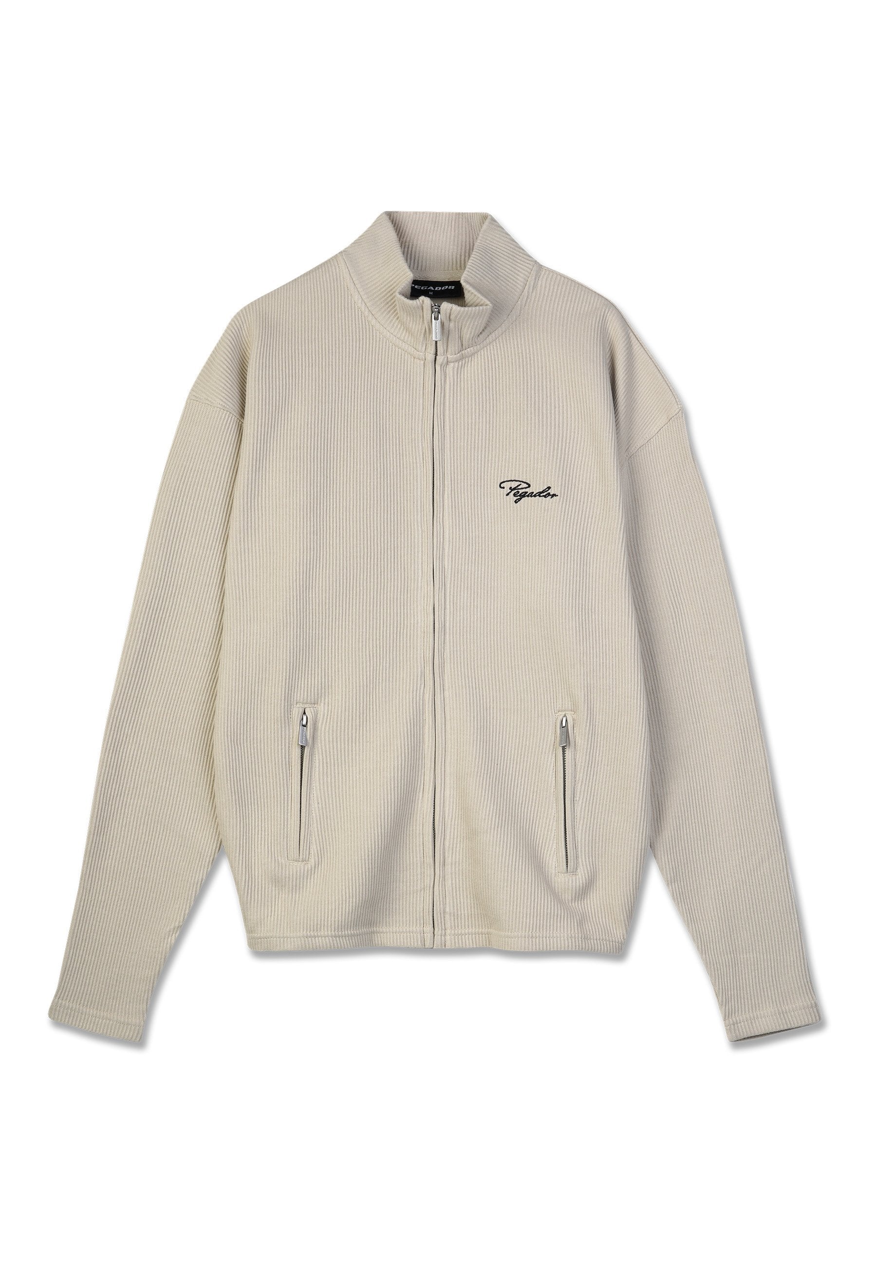 Beige gerippte Zip-Jacke mit Stehkragen, zwei mit Reißverschluss versehenen Fronttaschen und kleinem schwarzen gestickten Text auf der linken Brust.