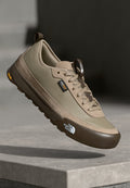 Beige Sportschuh mit Obermaterial aus Mesh und Wildleder, brauner Gummisohle, gepolstert, mit Logoakzenten und Schnürdesign.