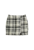 Tweed-Minirock mit einem schwarz-weißen Karomuster, ausgestattet mit einem seitlichen Schlitz und strukturiertem Stoff. Gerade Passform mit einem glatten Taillenbund.
