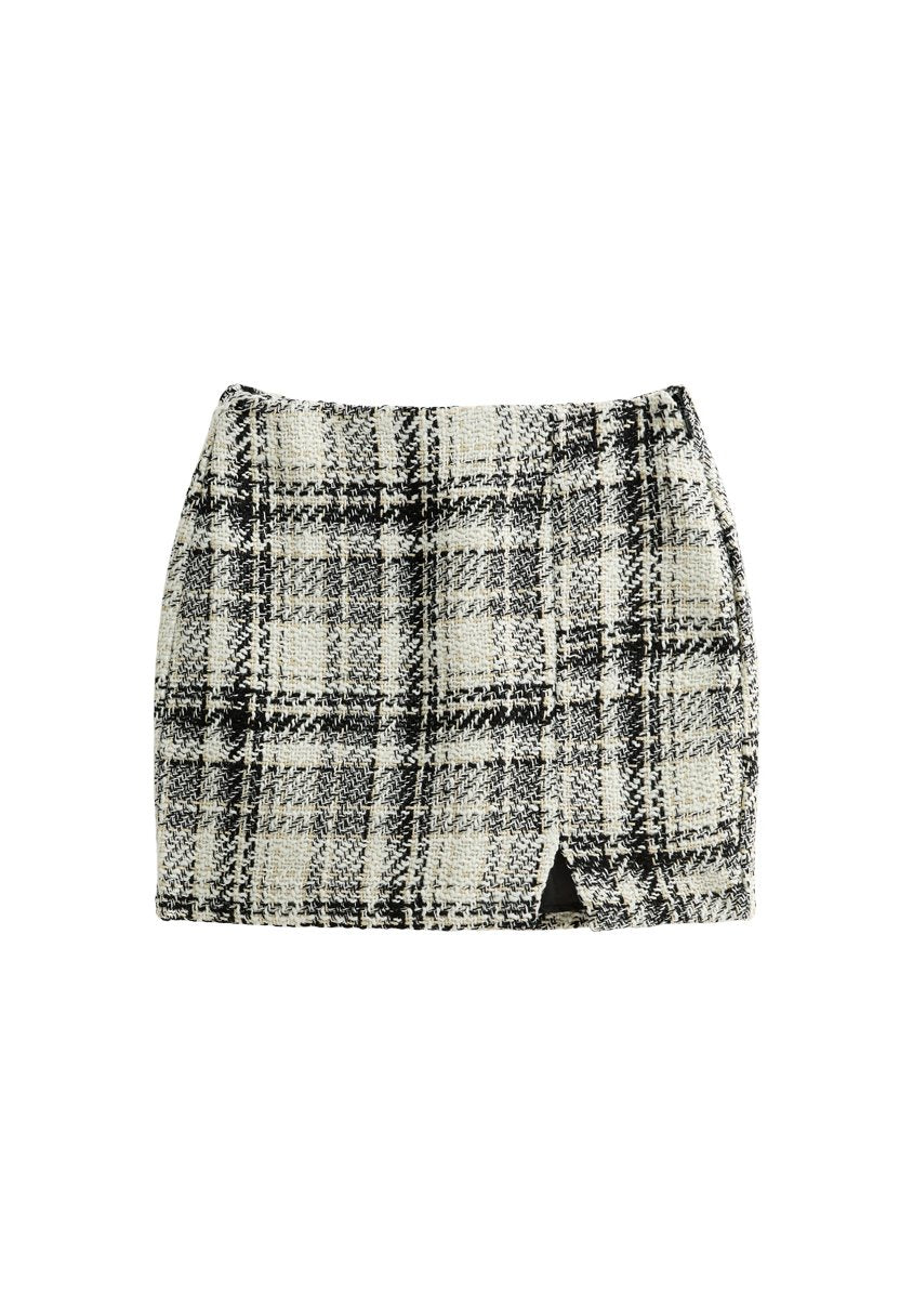 Tweed-Minirock mit einem schwarz-weißen Karomuster, ausgestattet mit einem seitlichen Schlitz und strukturiertem Stoff. Gerade Passform mit einem glatten Taillenbund.