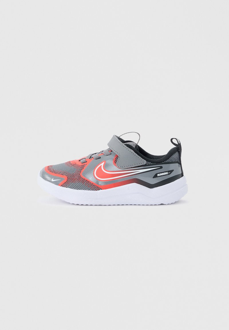 Grauer und roter Nike-Laufschuh für Kinder mit weißer Sohle, Klettverschluss und Mesh-Obermaterial, seitlich auf hellem Hintergrund dargestellt.