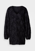 Schwarze Bluse mit langen Ärmeln und V-Ausschnitt, die mit einem strukturierten Blumenmuster versehen ist. Die Ärmel sind an den Handgelenken gerafft für einen lockeren Sitz.