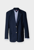 Marineblauer einreihiger Blazer mit zwei silbernen Knöpfen, Notch-Revers, Pattentaschen und gestreiften Hemdmanschetten, die an den Ärmeln sichtbar sind.
