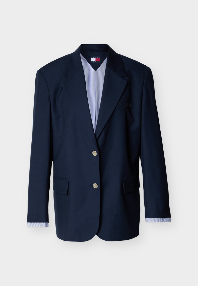 Marineblauer einreihiger Blazer mit zwei silbernen Knöpfen, Notch-Revers, Pattentaschen und gestreiften Hemdmanschetten, die an den Ärmeln sichtbar sind.