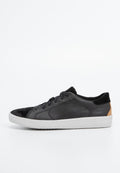 Schwarze Ledersneaker mit Akzenten aus Wildleder, weißer Sohle, runder Form und flachen Schnürsenkeln. Mit einem kleinen, braunen Logo an der Ferse.