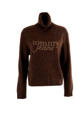 Brauner Rollkragenpullover aus strukturiertem Strickmaterial. Verfügt über das "Tommy Jeans"-Logo in einer helleren Nuance, mit bunten Flecken überall.