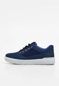 Navyblaue Sneaker aus einer Mischung aus Wildleder und Stoff, mit weißer Gummisohle, runden Schnürsenkeln und einem Logo an der Seite. Glatte Textur und schlichtes Design.