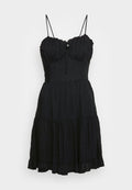 Schwarzes, mehrstufiges Kleid mit dünnen, verstellbaren Trägern, strukturiertem Stoff und dezentem Punkte-Muster. Mit tailliertem Oberteil und ausgestellt geschnittenem Saum.