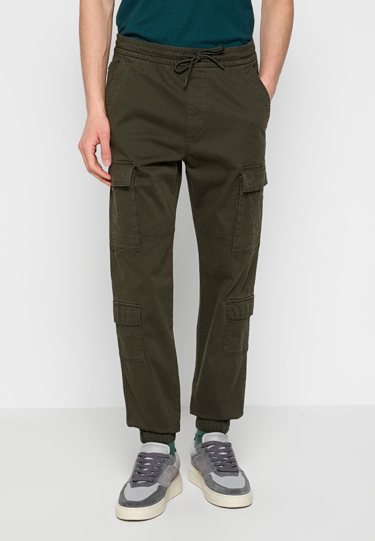 Cargo-Hosen aus dunkelolivgrünem Stoff mit einem elastischen Bund, Kordelzugverschluss und mehreren Cargo-Taschen an den Seiten.