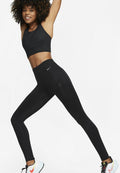 Schwarzes Sportoutfit mit einem strukturierten Cropped-Top und hochgeschnittenen Leggings mit einer Seitentasche, kombiniert mit mehrfarbigen Laufschuhen.