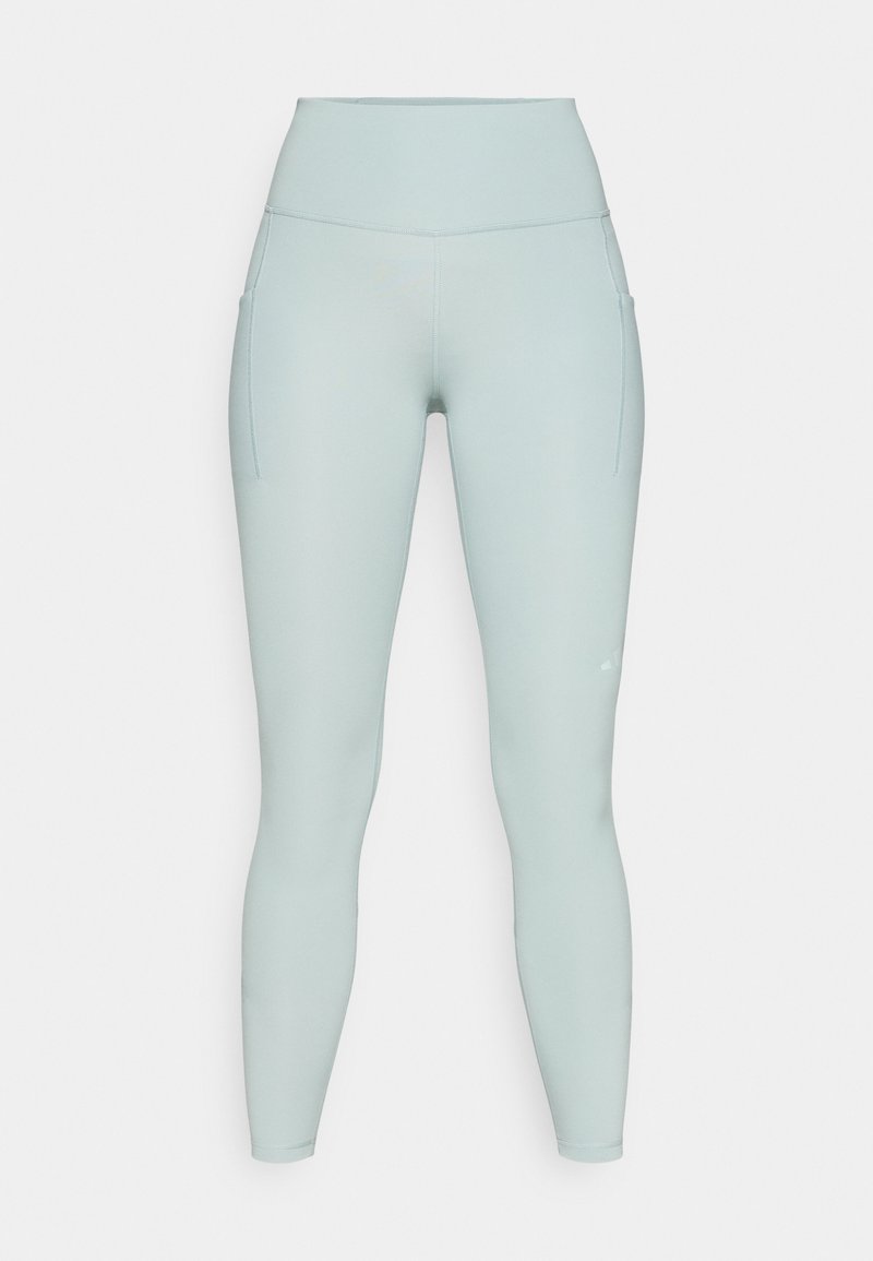 Hellblaue Leggings mit hoher Taille aus dehnbarem Material, ausgestattet mit Seitentaschen. Glatte Textur mit minimalen Nahtdetails.