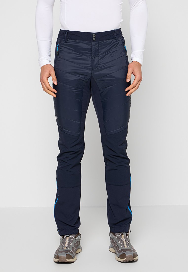 Marineblaue isolierte Hose mit glatter Textur, seitlichen Taschen, kontrastierenden blauen Akzenten und einem schmal zulaufenden Design.