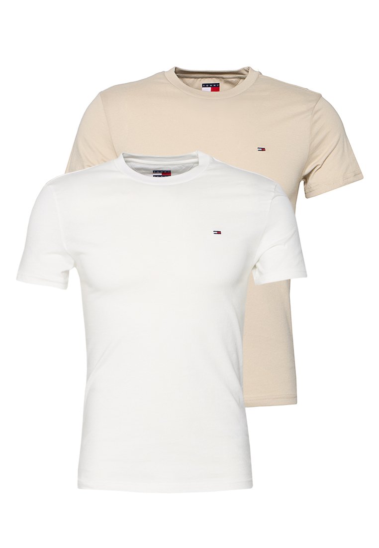 Zwei schlichte kurzärmelige T-Shirts mit Rundhalsausschnitt, eines vorne weiß und eines hinten beige, beide mit kleinen Tommy Hilfiger Logos auf der Brust.
