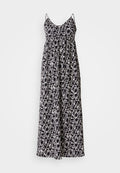 Maxikleid mit dünnen Trägern, das ein schwarz-weißes geometrisches Muster aufweist. Hergestellt aus leichtem Stoff, hat es eine lockere A-Linien-Form.
