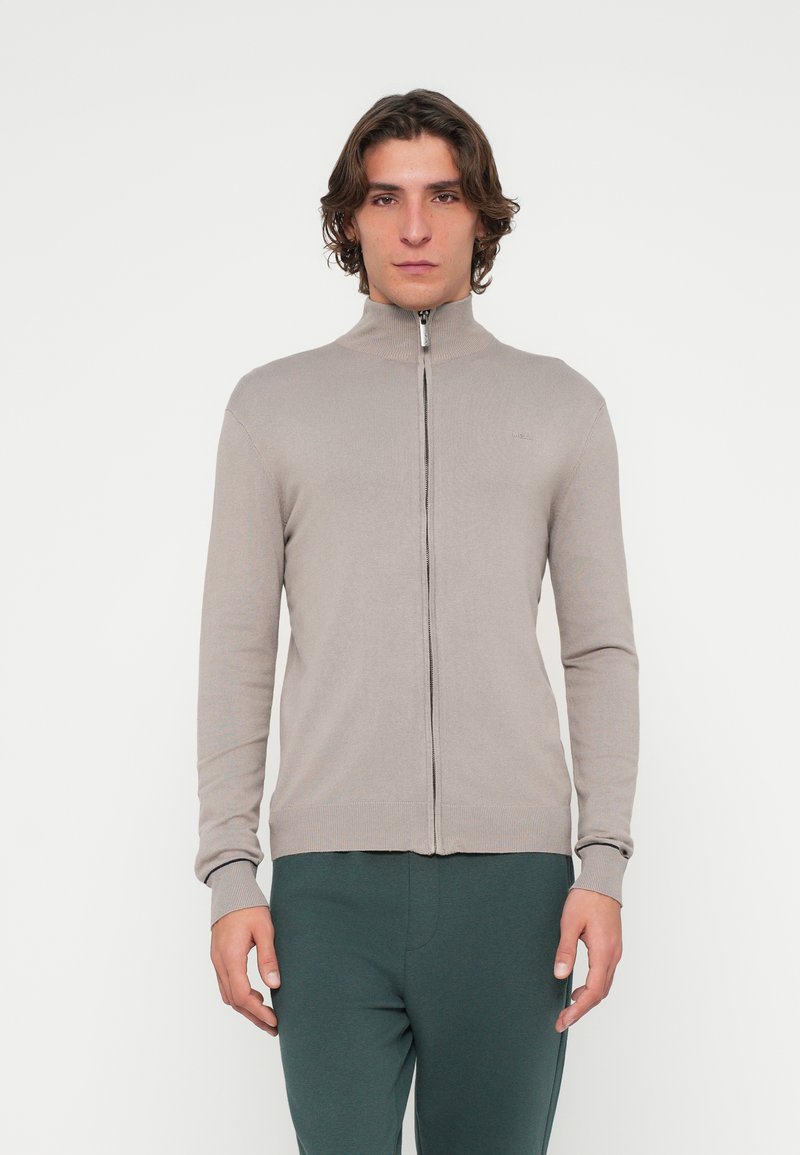 Hellgraue Cardigan mit Reißverschluss, hohem Kragen und gerippten Bündchen, gefertigt aus einem glatten, strukturierten Stoff, mit enganliegenden Ärmeln und einem dezenten Logo gestaltet.