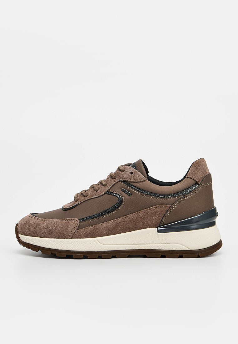 Brauner Sneaker mit Wildleder- und Ledereinsätzen, weißer Zwischensohle, schwarzen Akzenten und Gummiaußensohle, im Seitenprofil auf weißem Hintergrund dargestellt.