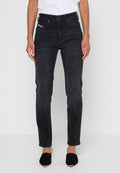 Schwarze Denim-Jeans mit schmaler Passform, mittelhohem Bund, fünf Taschen und dezenten Stickdetails. Getragen mit schwarzen Schuhen.