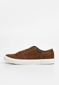 Braune Wildleder-Sneaker mit einer weißen Gummisohle, runder Zehenform, sechs Ösen und subtilen Nähdetails. Verfügt über ein blaues Markenetikett an der Seite.