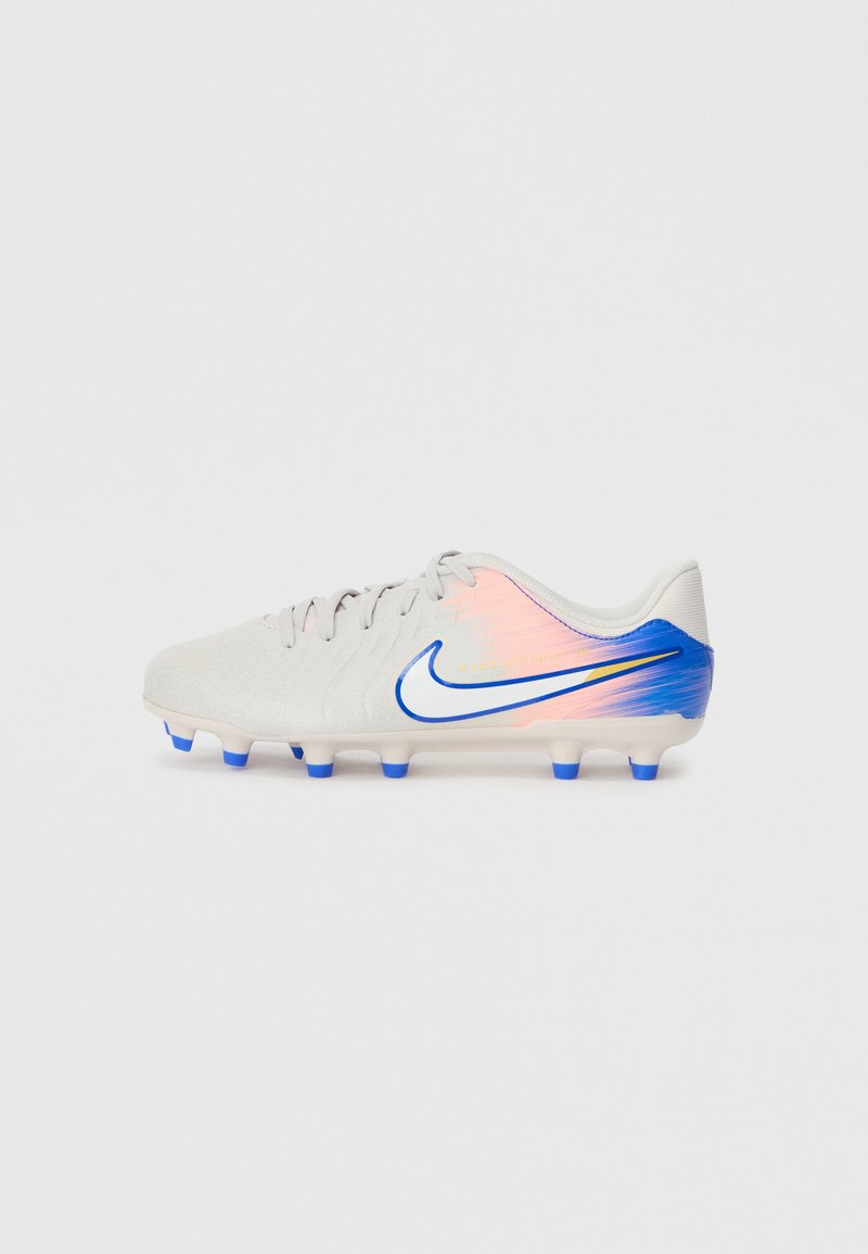 Weißer Nike Fußballschuh mit pinkem und blauem Farbverlauf am Fersenbereich, blauen Stollen und blau umrandetem Swoosh-Logo an der Seite.