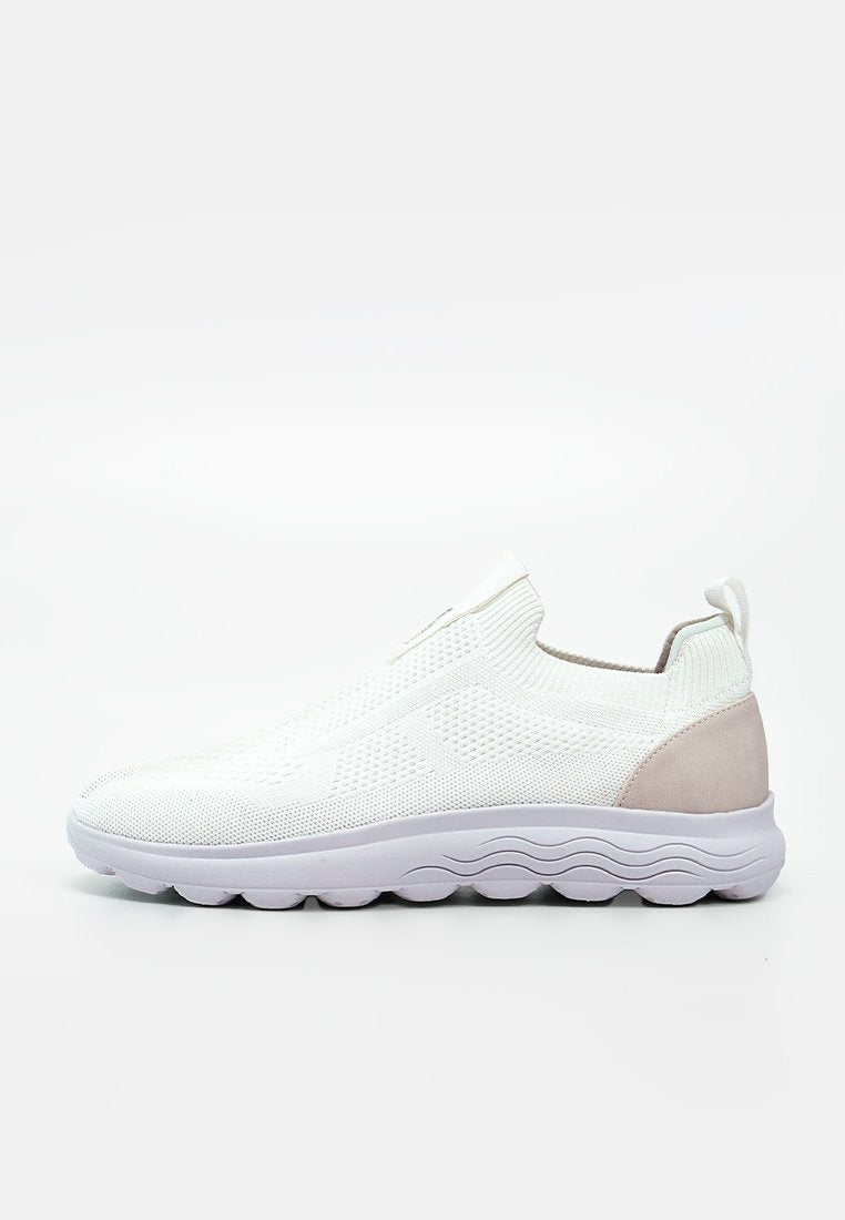 Weißer Slip-on-Sneaker mit gestricktem Obermaterial, beigem Fersenpatch, Zuglasche und dicker weißer Sohle mit wellenartigem Profil.