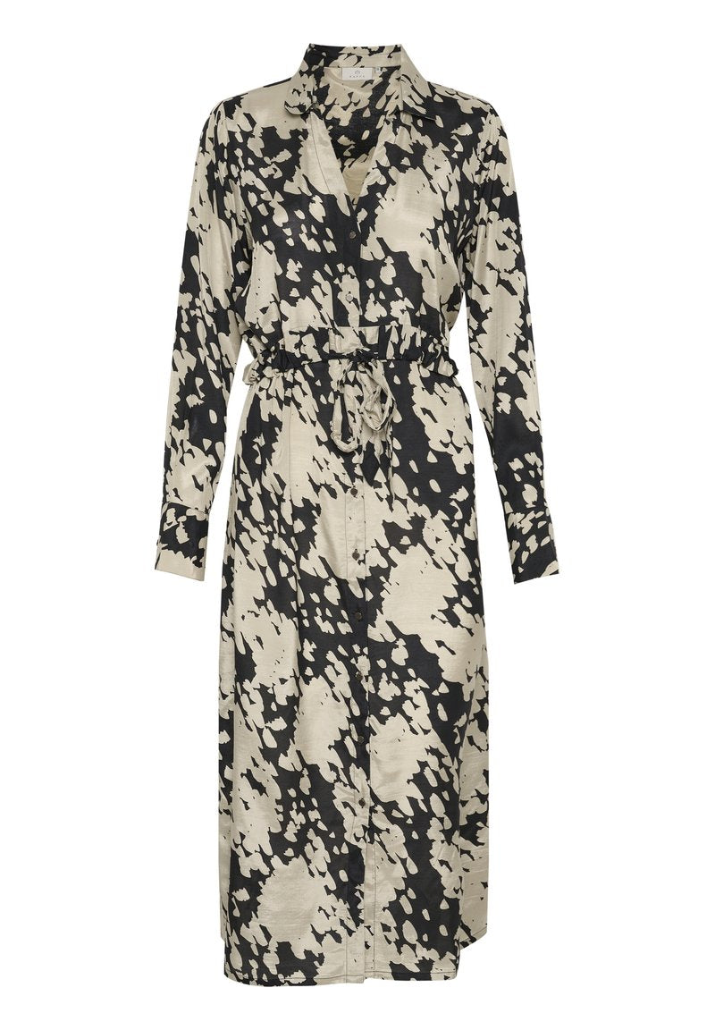 Langes, knöpfbares Kleid mit einem schwarz-beige gesprenkelten Muster. Hergestellt aus glattem Stoff, hat es eine taillierte Taille und lange Ärmel.