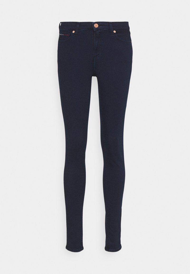 Schmale Jeans aus dunkelblauem Denim mit glatter Textur, ausgestattet mit einem Reißverschluss, zwei Fronttaschen und einem kleinen roten Akzent am Taschenrand.