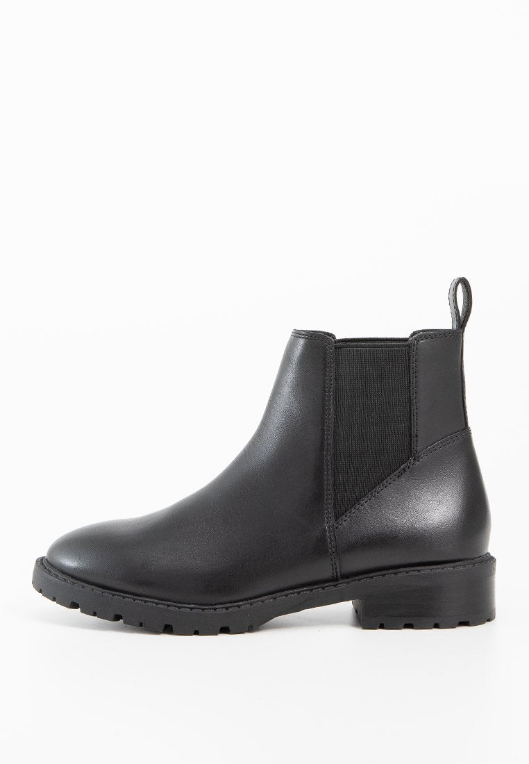 Schwarze Leder-Ankle-Boots mit elastischen Seiteneinsätzen, abgerundeter Zehenkante und niedrigem Blockabsatz. Texturiertes Gummilaufsohle für besseren Halt.