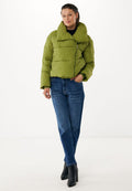 Olivgrüne Puffy-Jacke mit hohem Kragen und Reißverschluss, kombiniert mit blauen Jeans und schwarzen High-Heels. Glatte Stofftextur.