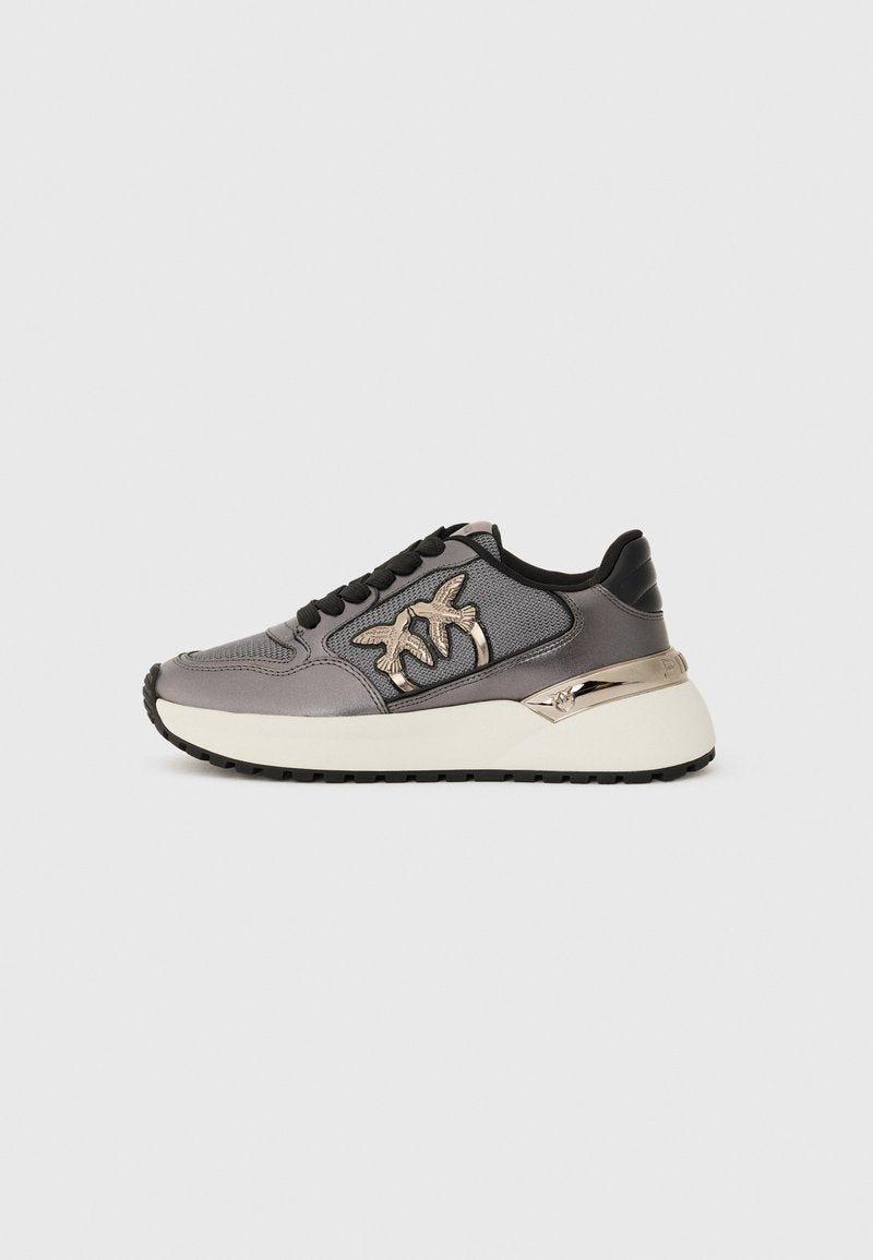 Graue Sneaker mit schwarzen Schnürsenkeln, Netzpaneelen, dicker weißer Sohle und metallic Vogelextras auf der Seite, von der Außenseite gezeigt.