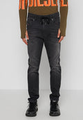 Dünne schwarze Denim-Jeans mit elastischem Bund und Kordelzug. Sie verfügen über fünf Taschen und eine verblasste Textur, kombiniert mit schwarzen Sneakern.