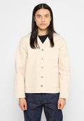 Beige Canvasjacke mit V-Ausschnitt, Knopfverschluss und zwei Fronttaschen. Besitzt eine strukturierte Oberfläche und braune Knöpfe als Kontrast.