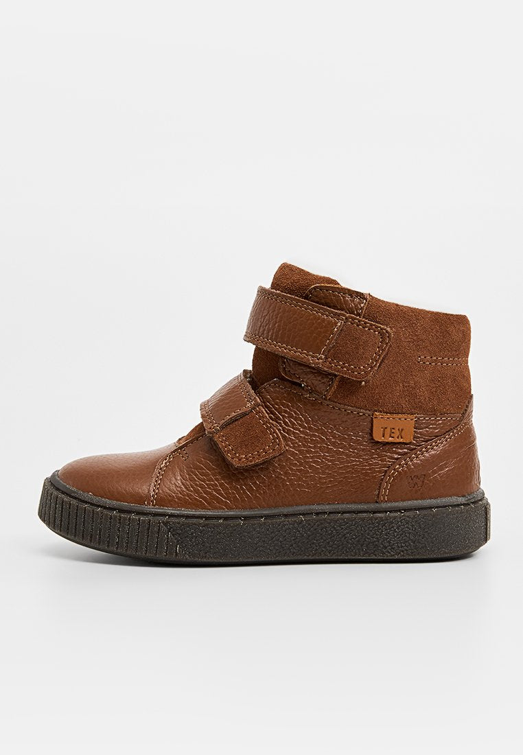 Braune Lederstiefelette mit strukturiertem Finish, ausgestattet mit zwei verstellbaren Klettverschlüssen und einer schwarz-gummierten Sohle mit Rillen.