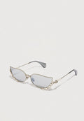 Katzenaugen-Sonnenbrille mit silbernem Rahmen, hellgrauen Gläsern und einer dekorativen Perlenakzent entlang der Oberseite. Schmale Bügel mit einem eleganten Design.