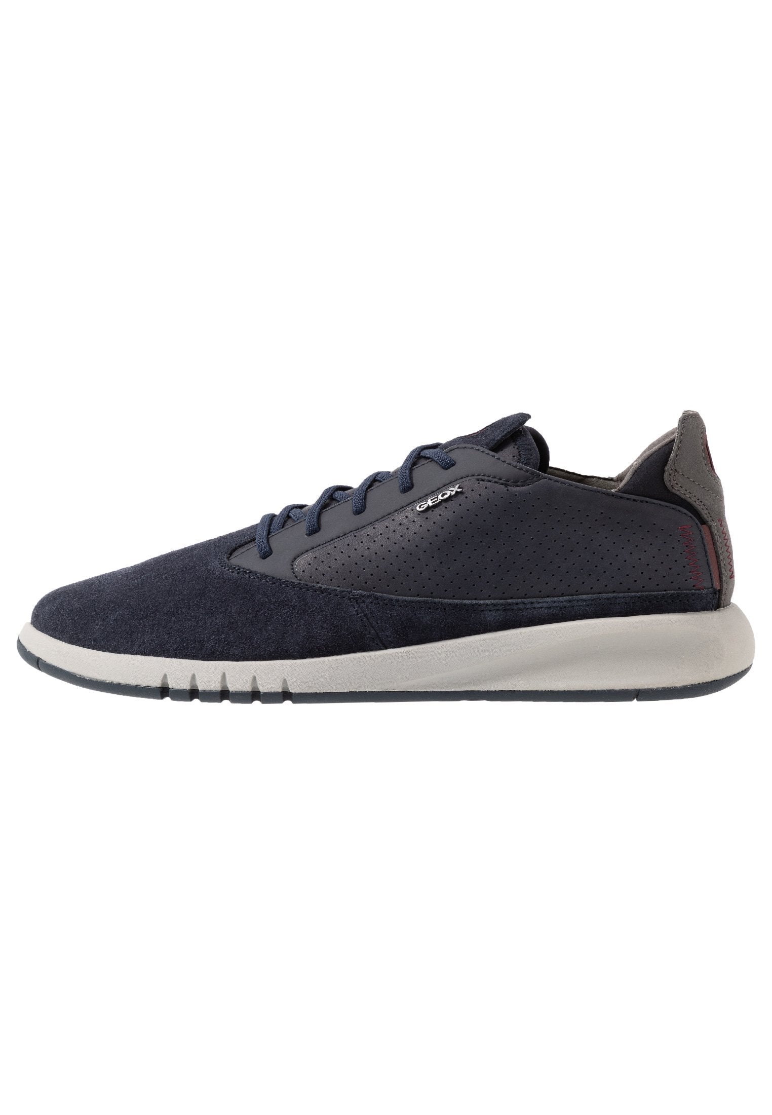Dunkelblaue Sneaker mit einem Obermaterial aus Wildleder und durchbrochenen Details, Schnürverschluss und einer hellgrauen Gummisohle. Subtiler Markenaufdruck an der Seite.