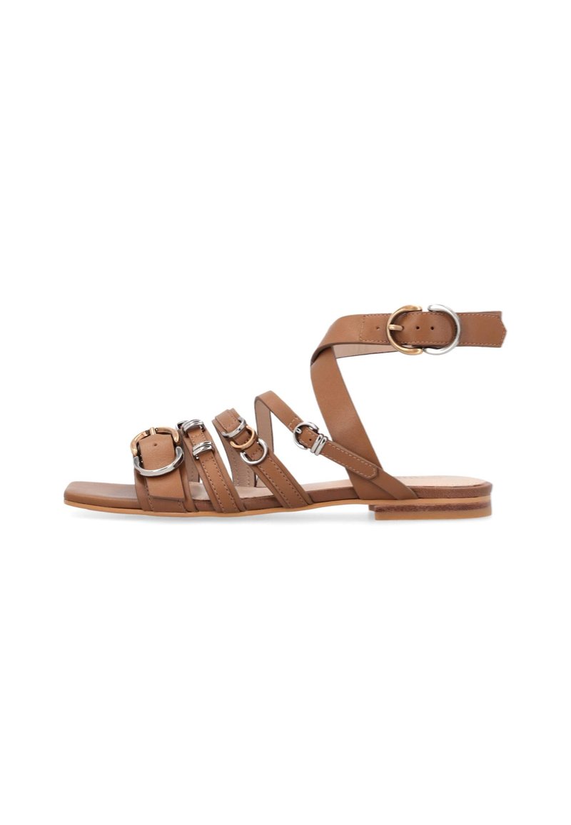 Braune Leder-Sandalen mit mehreren Schnallenriemen, flacher Sohle und minimalistischem Design. Akzentuierungen umfassen silberne und goldene Hardware-Details.