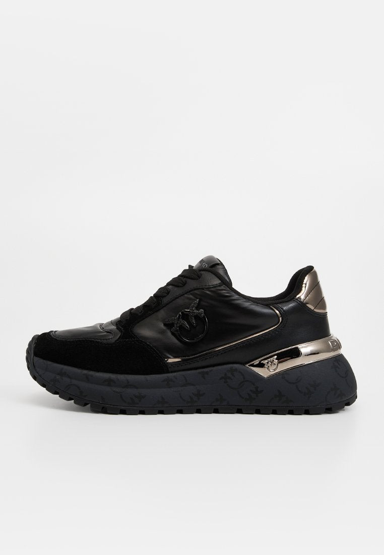Schwarzer Sneaker mit einer Kombination aus glattem Leder und Wildleder, metallischen Akzenten, einer gemusterten Sohle und einem stilisierten Logo.