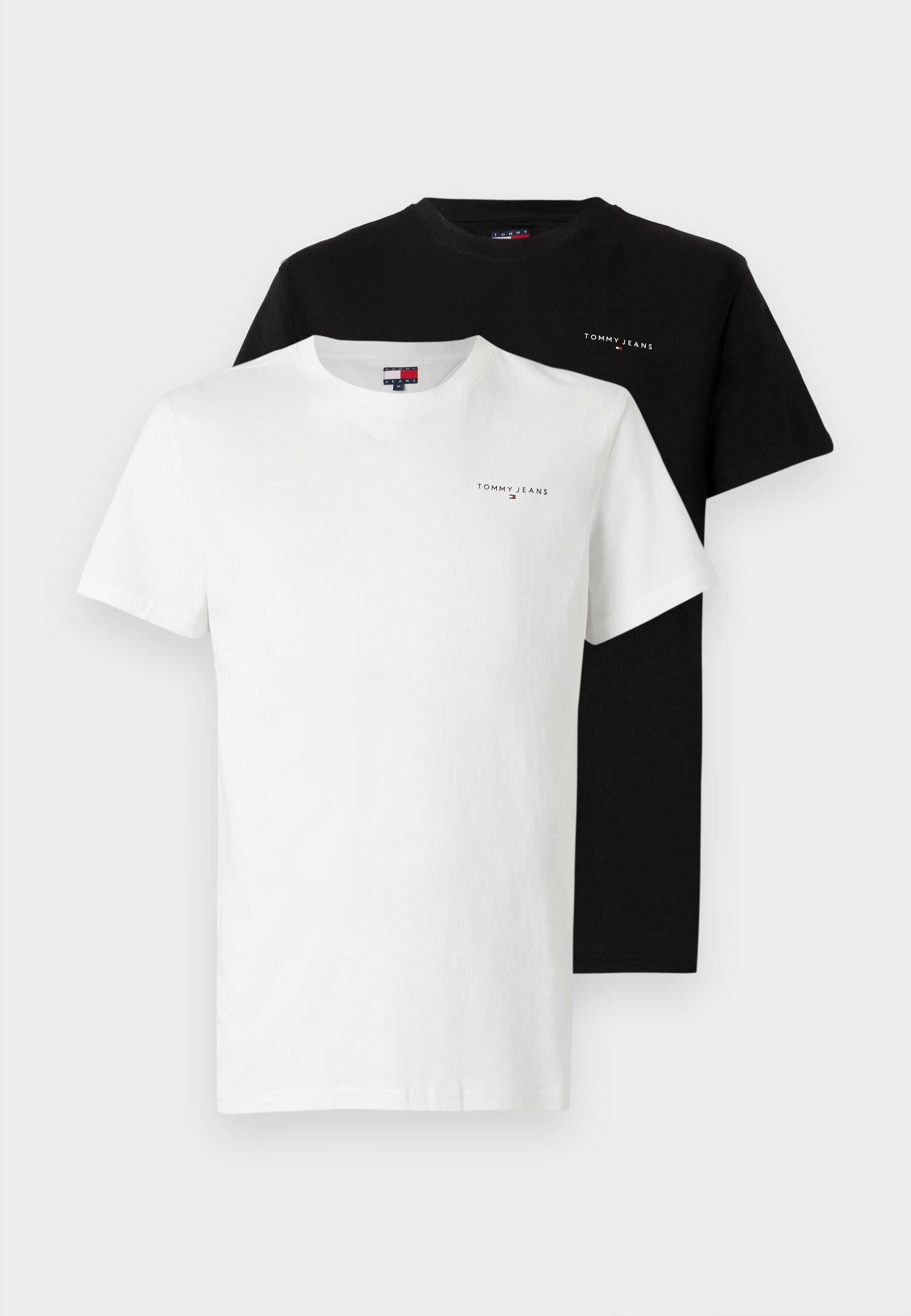 Zwei Rundhals-T-Shirts, eines in Weiß und eines in Schwarz, jeweils mit einem kleinen "Tommy Jeans"-Logo auf der linken Brust.