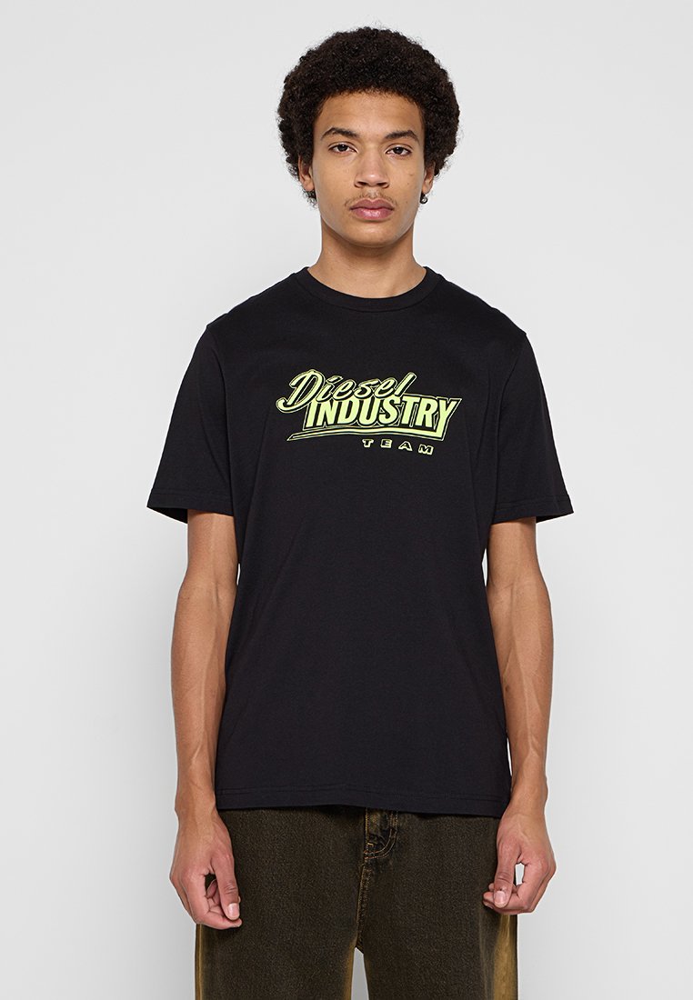 Schwarzes Baumwoll-T-Shirt mit einem leuchtend grünen "Diesel INDUSTRY TEAM"-Grafikaufdruck auf der Vorderseite, mit Rundhalsausschnitt und kurzen Ärmeln.