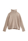 Beige Strickpullover mit hohem Rollkragen, überschnittenen Schultern und gerippten Abschlüssen. Weiche Textur und lockere, kastige Passform. Sieht leicht aus.