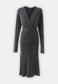 Schwarzes Kleid mit langen Ärmeln, tiefem Ausschnitt, gerafften Details an der Taille und silbernen Nieten, die gleichmäßig im Stoff verteilt sind.